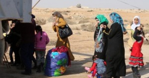 Iraqi women and children, who fled Fallujah, stand with their belongings near a truck as they wait at an army checkpoint at Ayn al-Tamer crossing at the entrance to Karbala province on January 6, 2014. Buses and cars carrying families fleeing the fighting in Fallujah and Ramadi from the western Iraqi province of Anbar, flock to the army checkpoint at the entrance to Karbala province, where the refugees are hoping to find a safehaven from the fighting.   AFP PHOTO/AHMAD AL-RUBAYE        (Photo credit should read AHMAD AL-RUBAYE/AFP/Getty Images)