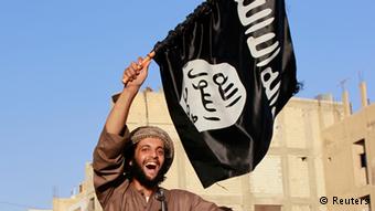 مقاتل داعشي يرفع علم النصر في غزوته